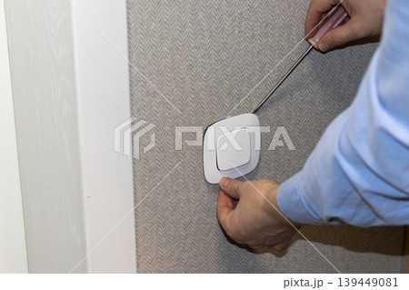 Electrician installing lighting switch. Interiors Electrician installing lighting switch. Interiors 139449081