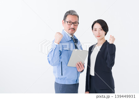 ビジネス(ガッツポーズの作業着の男性とスーツの女性) ビジネス(ガッツポーズの作業着の男性とスーツの女性) 139449931