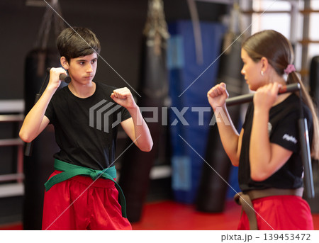 Teenagers holding nunchucks in their hands Teenagers holding nunchucks in their hands 139453472