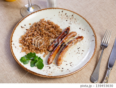 Fried sausages served with buckwheat groats Fried sausages served with buckwheat groats 139453630