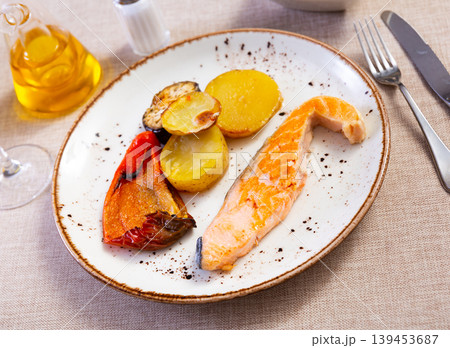 Salmon fillet served with potatoes, peppers and eggplant Salmon fillet served with potatoes, peppers and eggplant 139453687