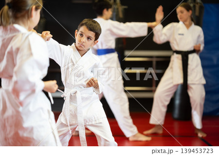 Boy and girl practice karate in pairs 139453723
