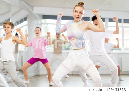 Team of teenagers rehearsing modern dances in dance hall 139453758
