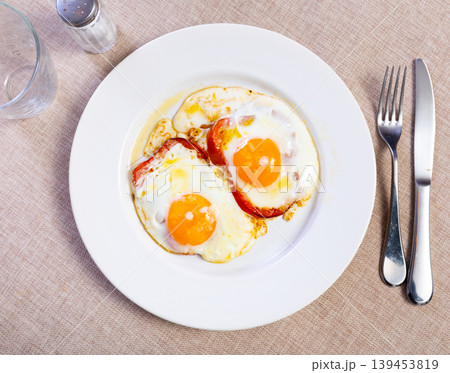 Fried eggs with bell peppers served on plate 139453819