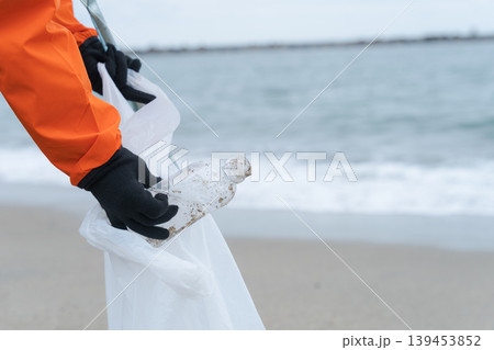 海岸に流れ着いたゴミを拾う人 海岸に流れ着いたゴミを拾う人 139453852