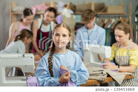 Teenage girl holding sewing work in clothing course Teenage girl holding sewing work in clothing course 139453869