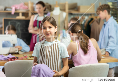 Positive girl child in study room of sewing school and young designers Positive girl child in study room of sewing school and young designers 139453906