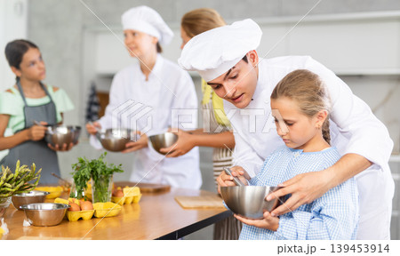 Young guy cook helps little girl to cook 139453914