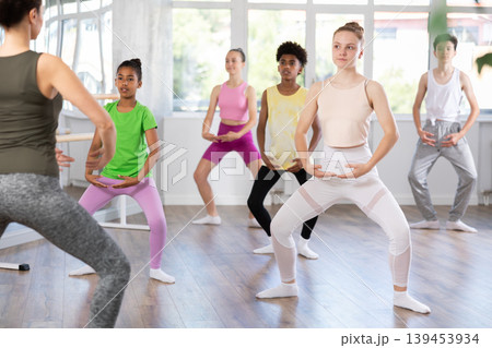 Teen girl participating in beginner group ballet class 139453934