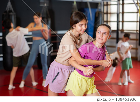 Two teenage girls practice self-defense in pairs Two teenage girls practice self-defense in pairs 139453936
