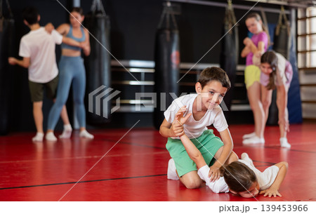 Boys practice self-defense strikes in the gym 139453966