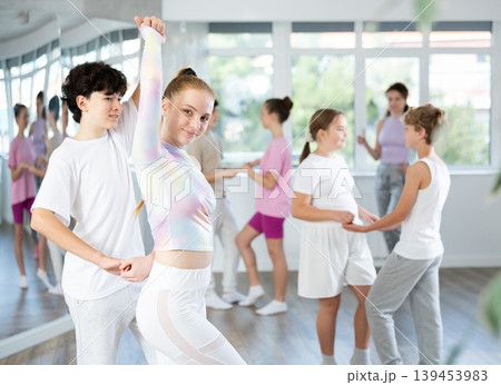 Girl dances Latin dance with male boy teen partner during choreography lesson 139453983
