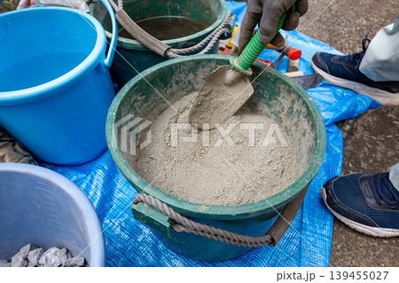 セメントをバケツで準備する建設作業の手元 139455027