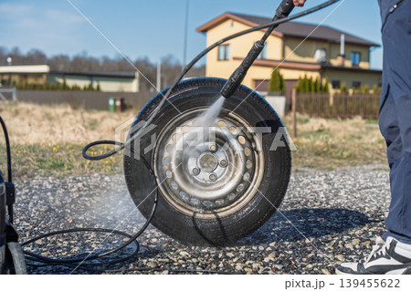 Car tire cleaning with high pressure washer, maintenance and care on driveway outdoors Car tire cleaning with high pressure washer, maintenance and care on driveway outdoors 139455622