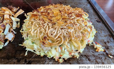 Hiroshima-style Okonomiyaki Japanese Savory Pancake Cooking on Teppan Grill Hiroshima-style Okonomiyaki Japanese Savory Pancake Cooking on Teppan Grill 139456125