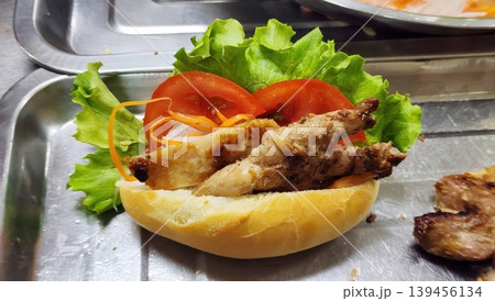 Traditional Vietnamese Banh Mi Sandwich with Grilled Meat and Fresh Vegetables on Metal Tray 139456134