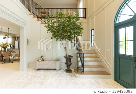 Luxury Home Entrance and Stairway Foyer with house plane and green door. Luxury Home Entrance and Stairway Foyer with house plane and green door. 139456398