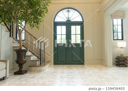 Luxury Home Entrance and Stairway Foyer with house plane and green door. Luxury Home Entrance and Stairway Foyer with house plane and green door. 139456403