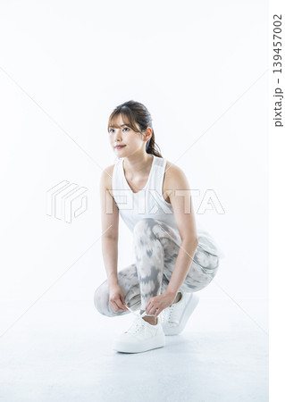 靴紐を結ぶスポーツウェアを着た若い女性 靴紐を結ぶスポーツウェアを着た若い女性 139457002