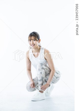 靴紐を結ぶスポーツウェアを着た若い女性 靴紐を結ぶスポーツウェアを着た若い女性 139457008