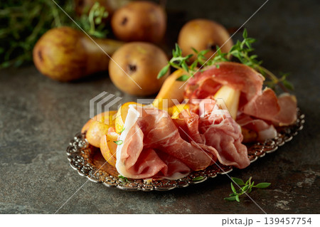 Prosciutto with pears and thyme on a silver tray. 139457754