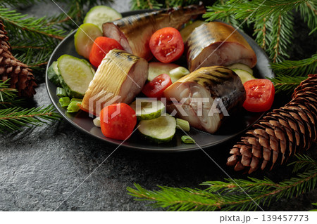 Smoked mackerel with fresh cucumbers, tomatoes and green onions on a black plate. Smoked mackerel with fresh cucumbers, tomatoes and green onions on a black plate. 139457773