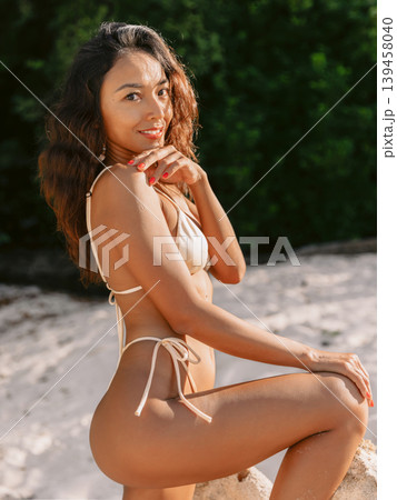 Smiles balinese woman in bikini on sandy beach Smiles balinese woman in bikini on sandy beach 139458040