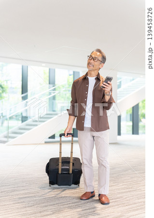 ホテルに宿泊する旅行者のシニア男性・スマホ予約 ホテルに宿泊する旅行者のシニア男性・スマホ予約 139458726