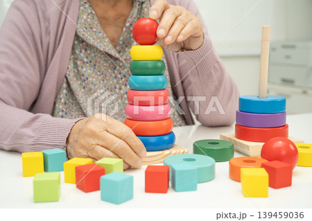 Alzheimer disease AD, Asian elderly woman patient suffering from dementia learn practical motor skills rehabilitation. Alzheimer disease AD, Asian elderly woman patient suffering from dementia learn practical motor skills rehabilitation. 139459036