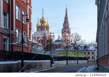 Russian Orthodox Church With Golden Domes on a Snowy Moscow Street Framed by Red Brick Buildings 139460029