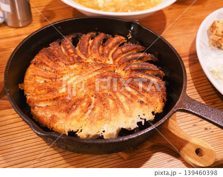 熱々のスキレットで提供される絶品円盤餃子 こんがりとした焼き色とパリパリの羽根 139460398