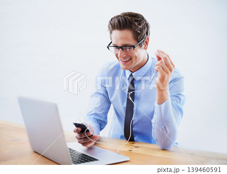 Headphones, business and man with a smartphone, laptop and listening to music in a workplace. Person, employee and consultant with a cellphone, sound and streaming audio with radio, podcast and smile Headphones, business and man with a smartphone, laptop and listening to music in a workplace. Person, employee and consultant with a cellphone, sound and streaming audio with radio, podcast and smile 139460591