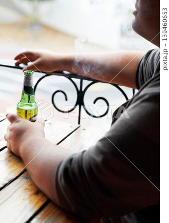 Outdoor, smoking and man with a beer, relax and weekend break at a restaurant, alcohol and pub. Person, outside and guy with cigarette, tobacco and drink with habit, bottle and peaceful with smoker Outdoor, smoking and man with a beer, relax and weekend break at a restaurant, alcohol and pub. Person, outside and guy with cigarette, tobacco and drink with habit, bottle and peaceful with smoker 139460653