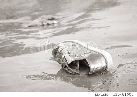 Golden shoe stranded washed up garbage pollution on beach Brazil. Golden shoe stranded washed up garbage pollution on beach Brazil. 139461009