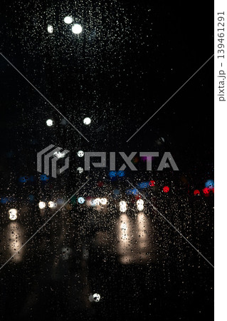 Rain on Window at Night with Blurred City Lights. Moody Urban Background. Raindrops Rain on Window at Night with Blurred City Lights. Moody Urban Background. Raindrops 139461291