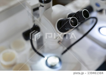 Close up of a scientific binocular microscope in use, highlighting biological research and precise laboratory workflow. Close up of a scientific binocular microscope in use, highlighting biological research and precise laboratory workflow. 139461384
