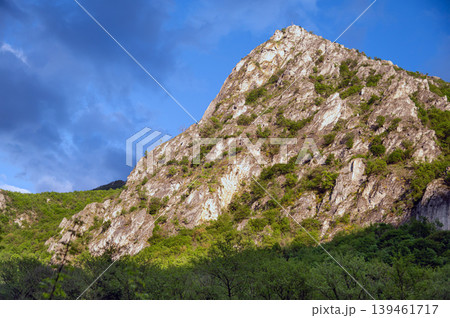 Rocks rise high in Matka Canyon near Skopje with clouds above and greenery on the slopes 139461717