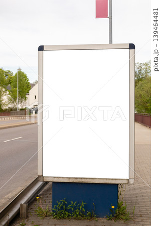 An empty advertising board is located on the side of the road in a quiet neighborhood. No advertisements are shown and nearby plants grow at the base of the board An empty advertising board is located on the side of the road in a quiet neighborhood. No advertisements are shown and nearby plants grow at the base of the board 139464481