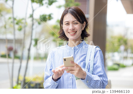 屋外でスマホを操作するミドル女性 屋外でスマホを操作するミドル女性 139466110