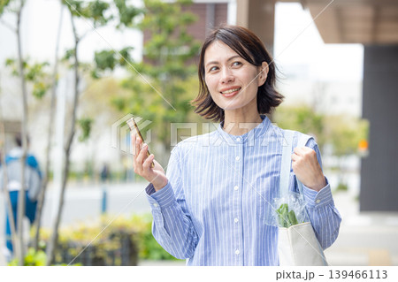屋外でスマホを操作するミドル女性 139466113