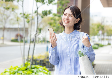 屋外でスマホを操作するミドル女性 屋外でスマホを操作するミドル女性 139466115