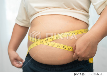 Asian woman with fat belly big size overweight and obesity with measure tape. 139466316