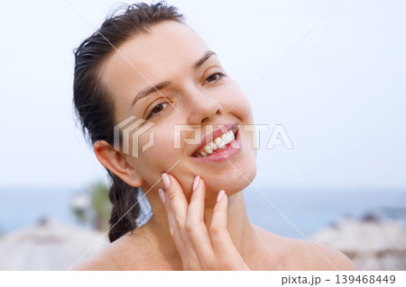 Beauty woman touching smooth facial complexion with radiant healthy glowing appearance outdoors naturally. Beautiful female applying sun cream and showing fresh skincare texture during daily beauty Beauty woman touching smooth facial complexion with radiant healthy glowing appearance outdoors naturally. Beautiful female applying sun cream and showing fresh skincare texture during daily beauty 139468449