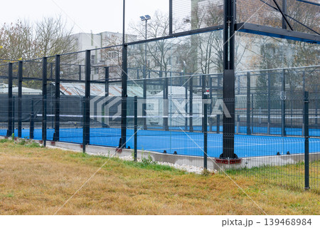 Modern outdoor padel court enclosed by glass and metal fencing Modern outdoor padel court enclosed by glass and metal fencing 139468984