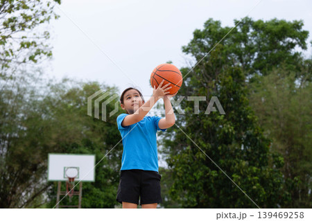 Asian student girl shooting a basketball on the school court, Back to school and healthy lifestyle concept. 139469258