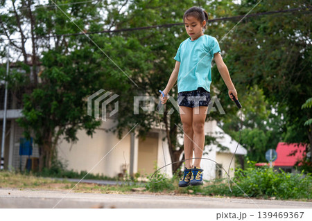 Back to school physical education: Asian girl jumping rope outdoors for exercise and fitness. Back to school physical education: Asian girl jumping rope outdoors for exercise and fitness. 139469367