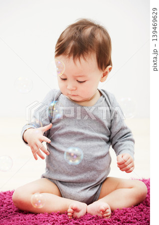 Baby, bubbles and playing game in home for childhood development, curious wondering or education. Kid, growth toys and mockup space or learning progress for sensory, coordination or entertainment 139469629