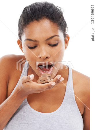 Diet, sweets and woman with chocolate, eating and wellness isolated on a white studio background. Cocoa, person and model with fitness, candy and unhealthy snack with mockup space, hungry and food 139469695