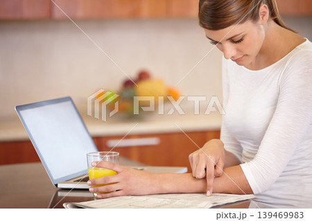 Woman, reading newspaper and kitchen with laptop, drinking orange juice and remote work at home. Computer, print media or freelancer check newsletter report for research, article information or story Woman, reading newspaper and kitchen with laptop, drinking orange juice and remote work at home. Computer, print media or freelancer check newsletter report for research, article information or story 139469983
