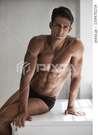 Muscular, man and sexy portrait sitting and relax in sunshine, white background or studio in Portugal. Shirtless, model and serious person with wellness and bodybuilder with fitness or confidence Muscular, man and sexy portrait sitting and relax in sunshine, white background or studio in Portugal. Shirtless, model and serious person with wellness and bodybuilder with fitness or confidence 139470254